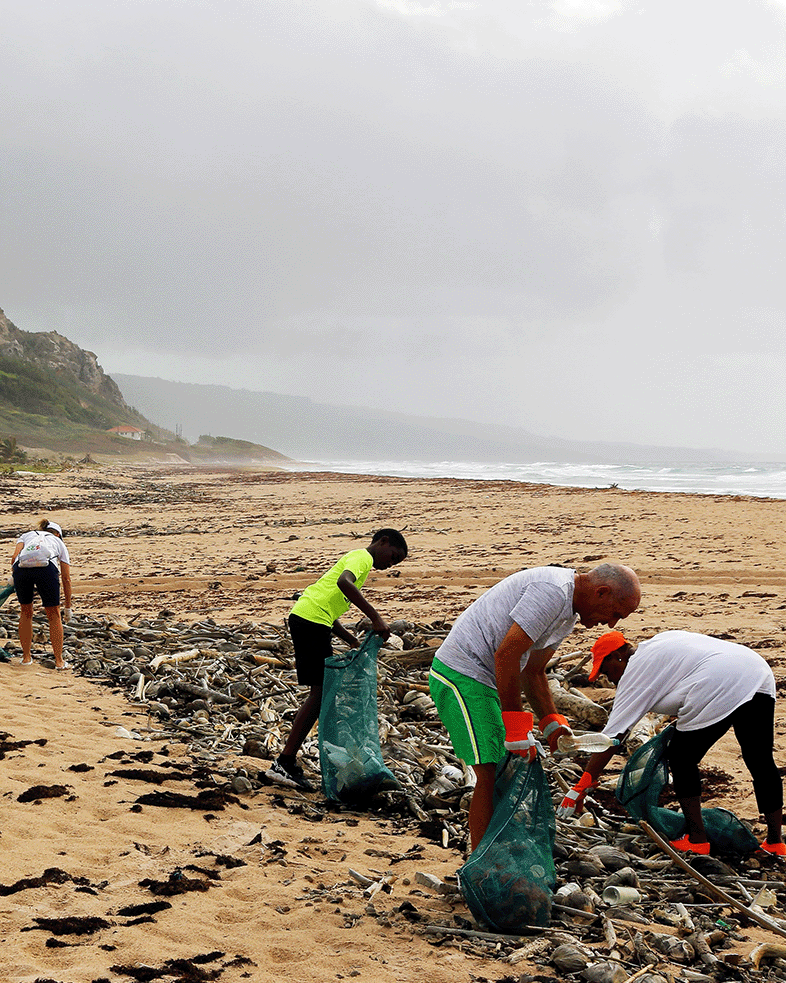 People participating in a beach cleanup on a cloudy day.