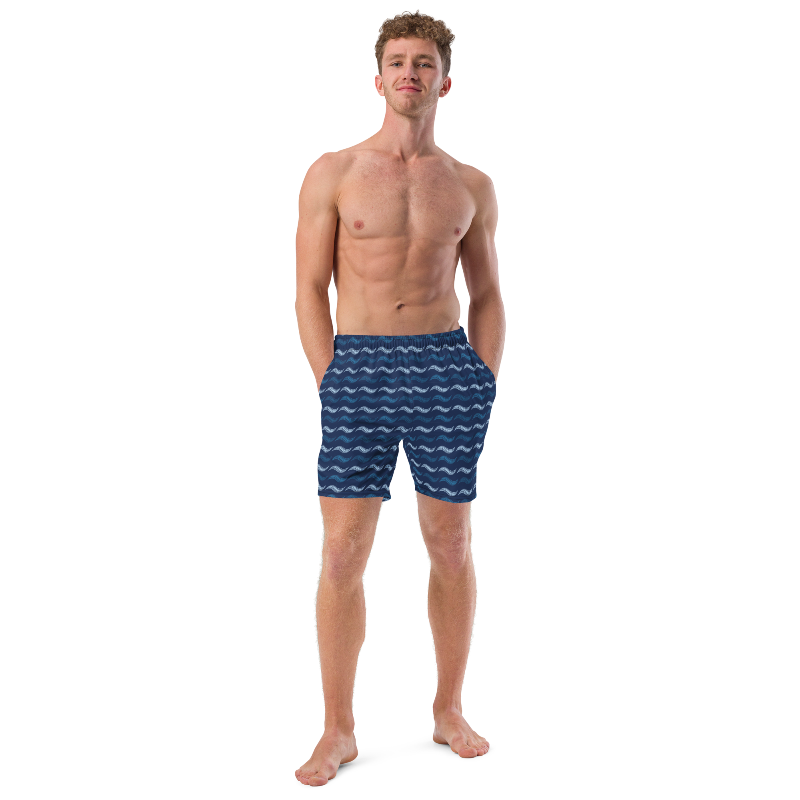 Man wearing blue swim shorts with wave pattern on a white background