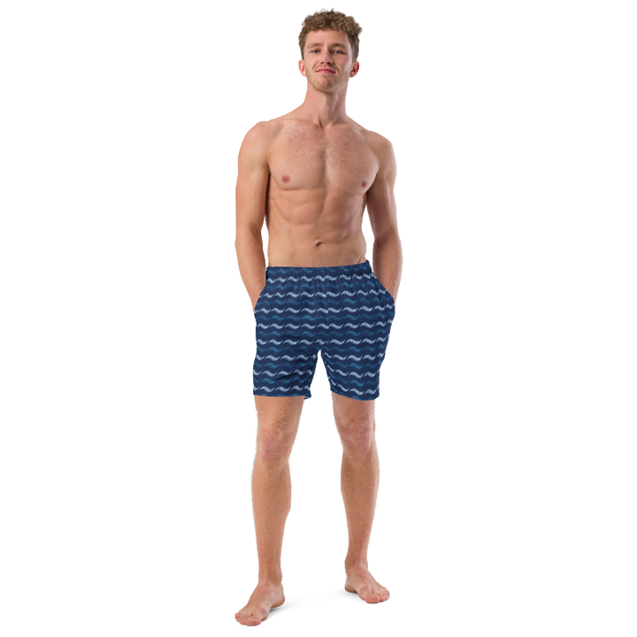 Man wearing blue swim shorts with wave pattern on a white background