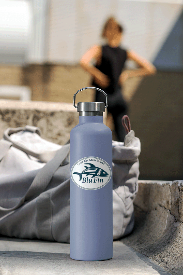 Purple water bottle with a logo on a stone surface with a blurred person in the background