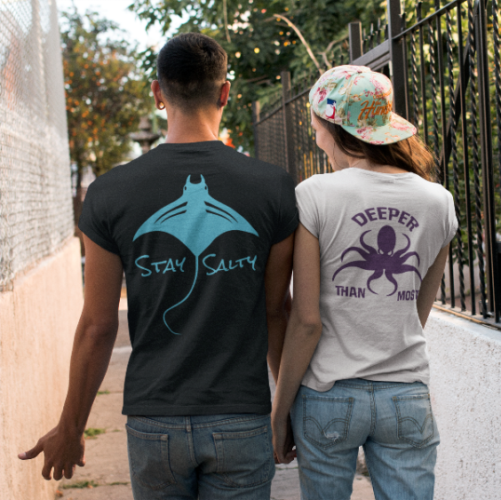 Two people walking away, each wearing a t-shirt with a graphic design and text.